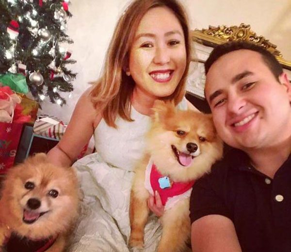 couple with their two little dogs next to christmas tree