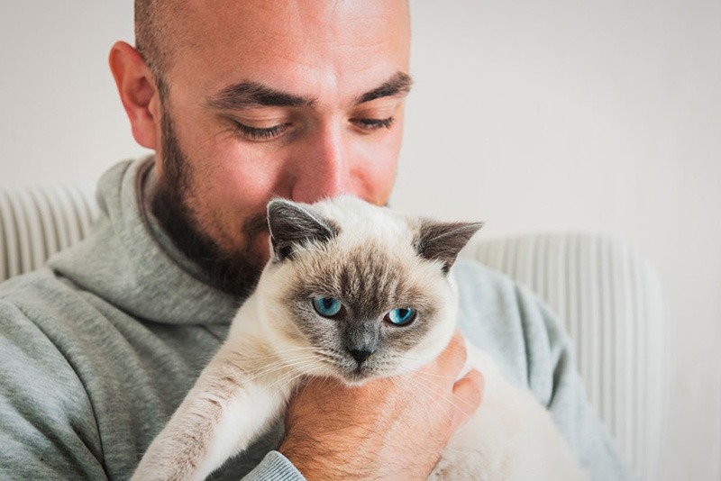 Man kissing his ESA cat